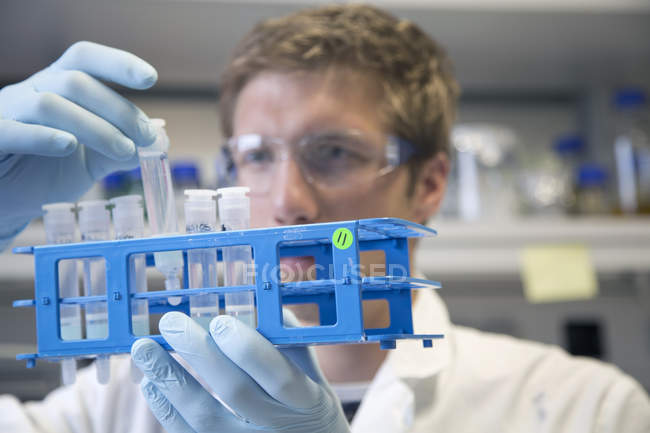 Cientista examinando tubos de ensaio em um laboratório biológico — Fotografia de Stock