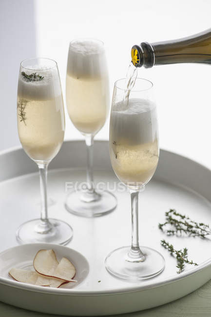 Tablett with three champagne flutes of champagne with pear purree and thyme — Stock Photo