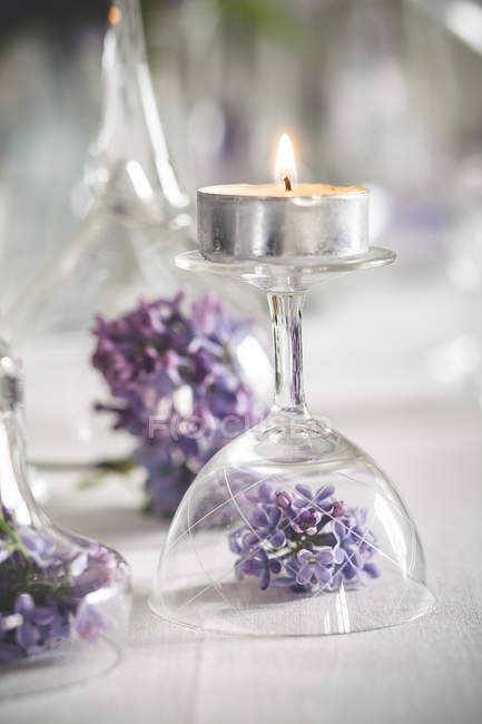 Primo piano della decorazione della tavola con candele da tè, bicchieri e lilla — Foto stock