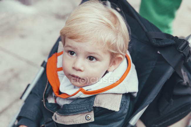 Retrato de bonito sério loiro menino no carrinho — Fotografia de Stock