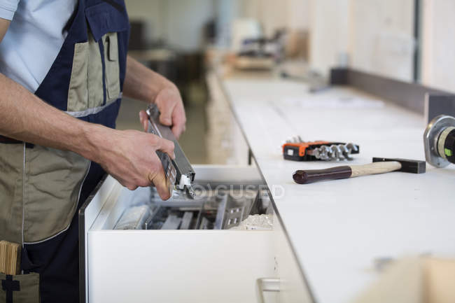 Handwerker hält Stück Metall — Stockfoto