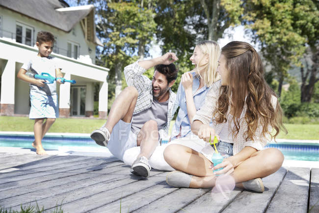 Famiglia felice a bordo piscina — Foto stock