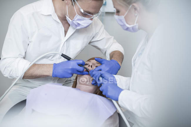Dentista realizando um check-up rotineiro para seu paciente — Fotografia de Stock