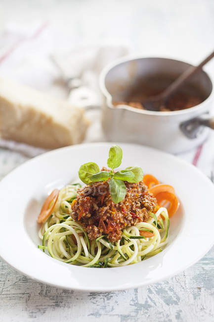Zoodles, Spaghetti made from Zucchini, with bolognese sauce on weathered wooden surface — Stock Photo