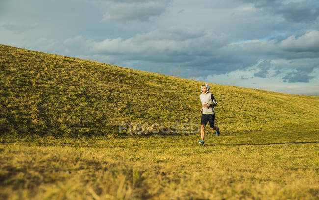 Giovane che fa jogging nel prato — Foto stock