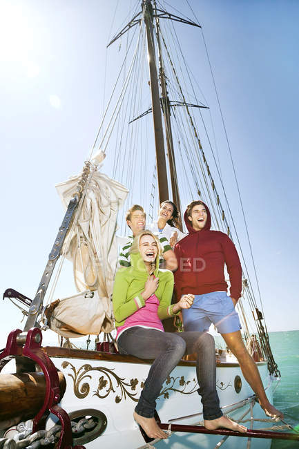 Felices amigos en un velero - foto de stock