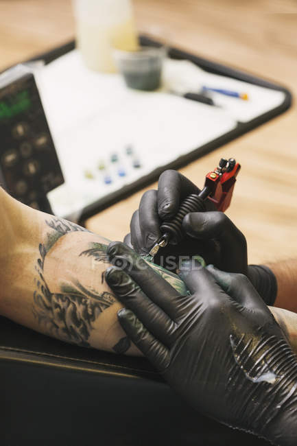Immagine ritagliata del tatuatore al lavoro in studio — Foto stock