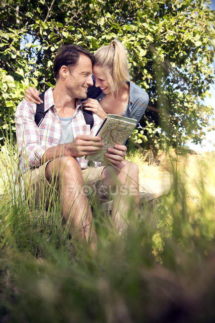 Felice coppia escursionistica con mappa prendersi una pausa — Foto stock