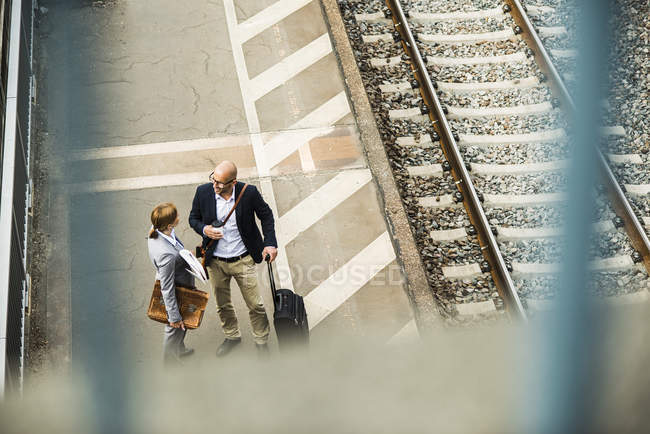 Uomo d'affari e donna d'affari che parlano sulla piattaforma ferroviaria — Foto stock