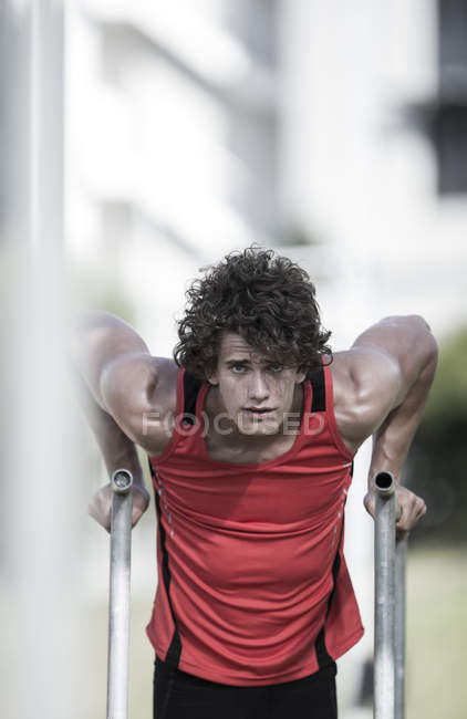 Portrait of young sportsman doing chin-ups — Stock Photo