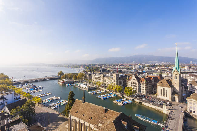 Suiza, Zurich, Paisaje urbano con Limmat River, Town House Quai, Fraumuenster Church y Muenster Bridge en un día soleado - foto de stock