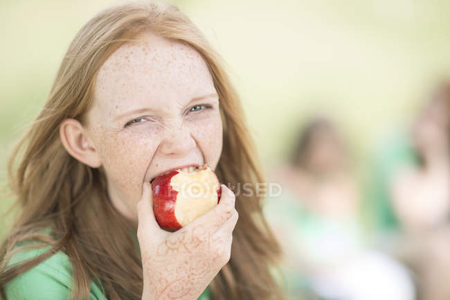 Ritratto di ragazza con i capelli rossi che mangia una mela — Foto stock