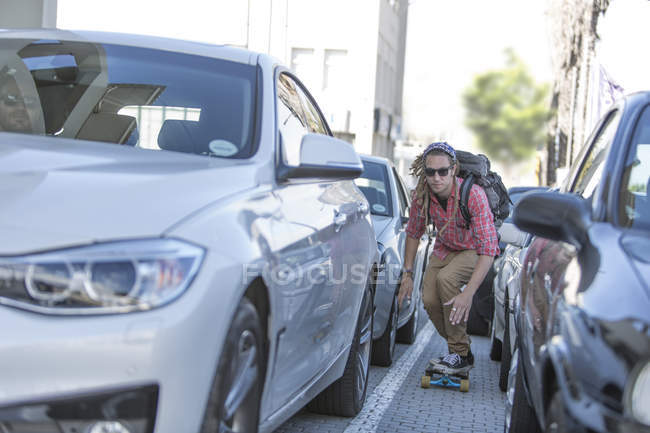 Young man on skateboard in traffic jam — Stock Photo