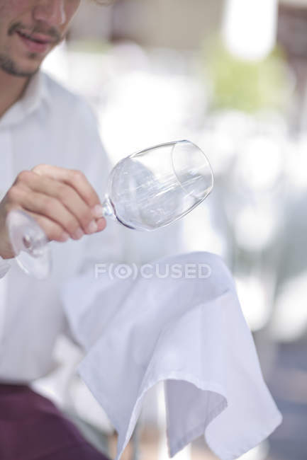 Cameriere pulire un bicchiere di vino con un panno — Foto stock