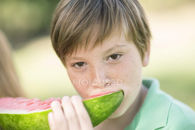 Retrato de niño comiendo rebanada de sandía - foto de stock