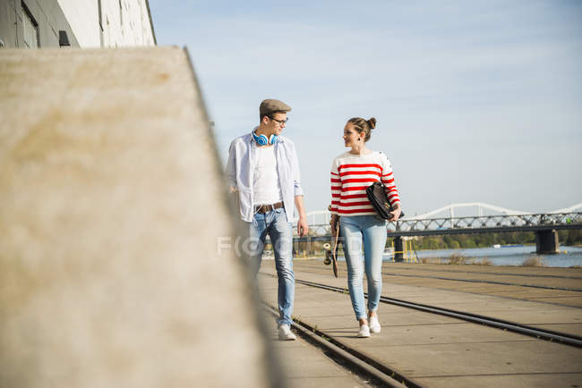Jovem e mulher caminhando na trilha à beira do rio — Fotografia de Stock