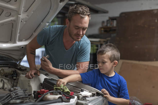 Hijo ayudando a padre en casa garaje trabajando en el coche — reparación  de, taller - Stock Photo | #181526758