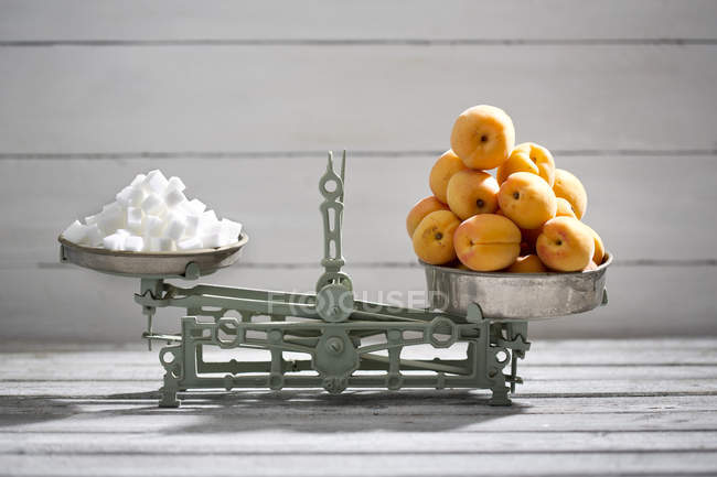 Abricots et cubes de sucre sur écailles — Photo de stock