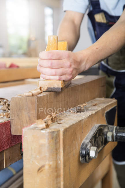 Carpintero cepillado madera en taller - foto de stock