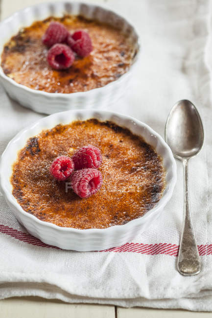Elevated view of creme brulee with berries and spoon — Stock Photo