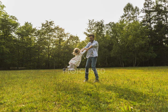 Pai feliz transformando filha no prado — Fotografia de Stock