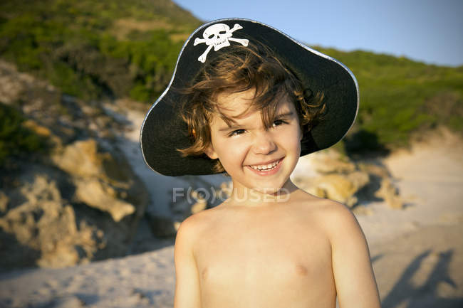 Retrato de menino sorridente usando chapéu de pirata na praia — Fotografia de Stock