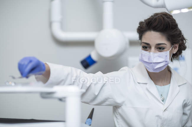 Dentista femenina examinando paciente con espejo bucal - foto de stock