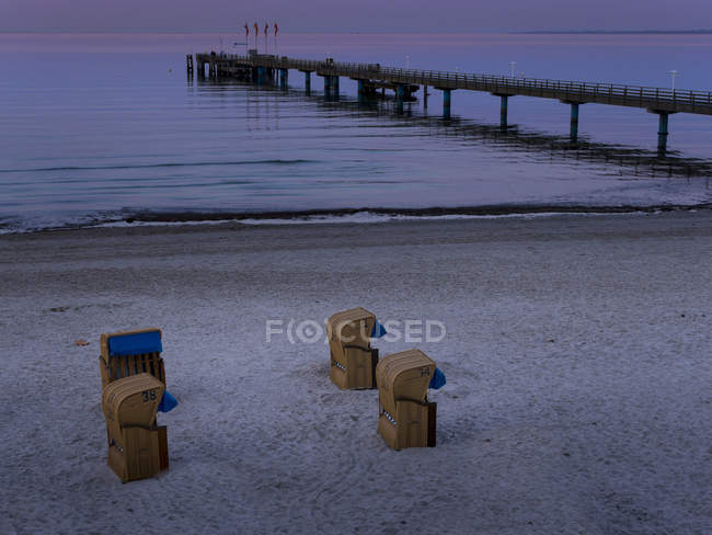 Germania, Schleswig-Holstein, Scharbeutz, Ponte sul mare e sedie a sdraio in vimini sulla spiaggia — Foto stock
