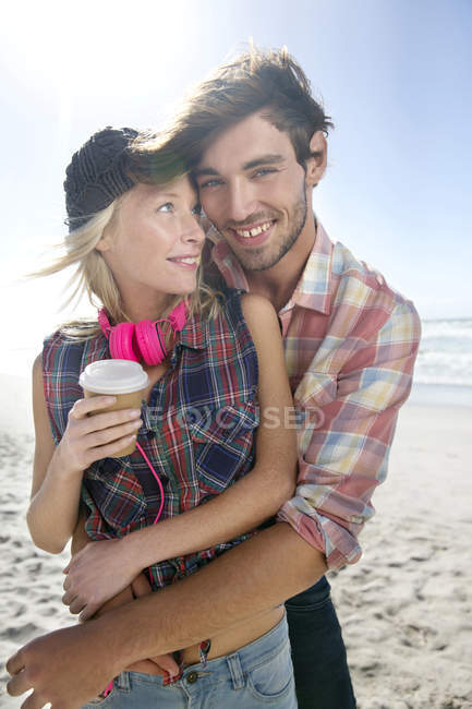 Glückliches junges Paar umarmt sich am Strand — Stockfoto