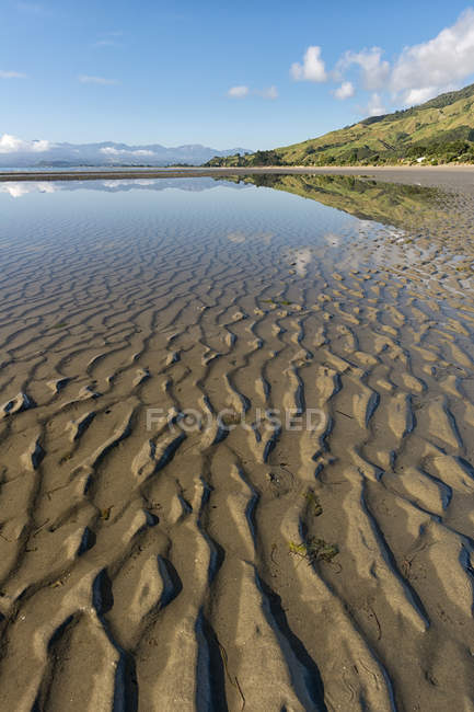 Нова Зеландія Тасман Golden Bay, Pakawau, відображення хмарах у воді і споруд на піску, під час відливу — Stock Photo