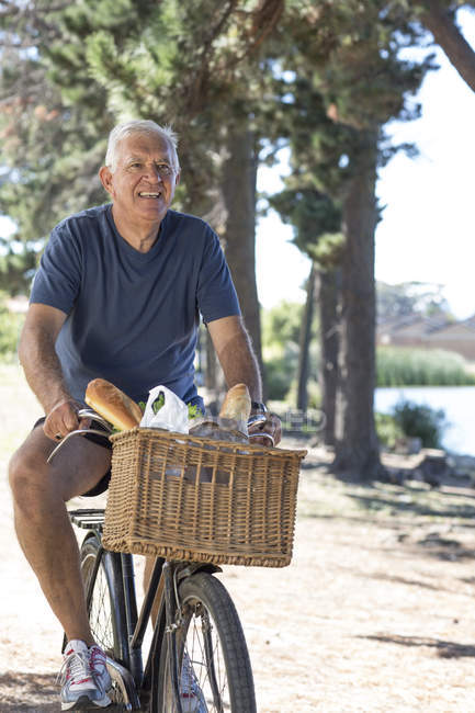 Sonriente hombre mayor en bicicleta al aire libre - foto de stock