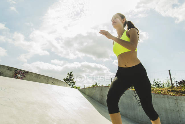 Jeune femme jogging dans un skate park — Photo de stock