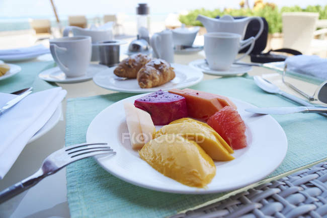 Surtido de fruta fresca para el desayuno en la mesa - foto de stock