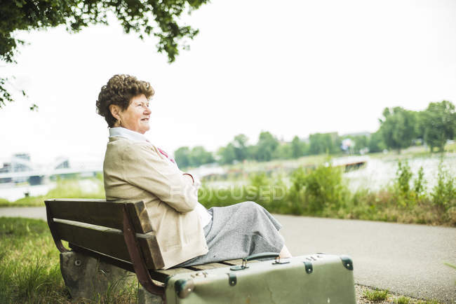Senior mulher sentada no banco — Fotografia de Stock
