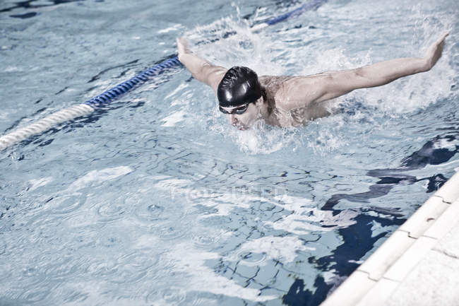 Treinamento de nadador caucasiano na piscina interior — Fotografia de Stock