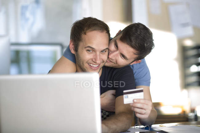 focused_181533904-stock-photo-happy-gay-couple-laptop-shopping.jpg