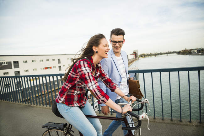 Alemania, Mannheim, joven y mujer con bicicleta en el puente - foto de stock