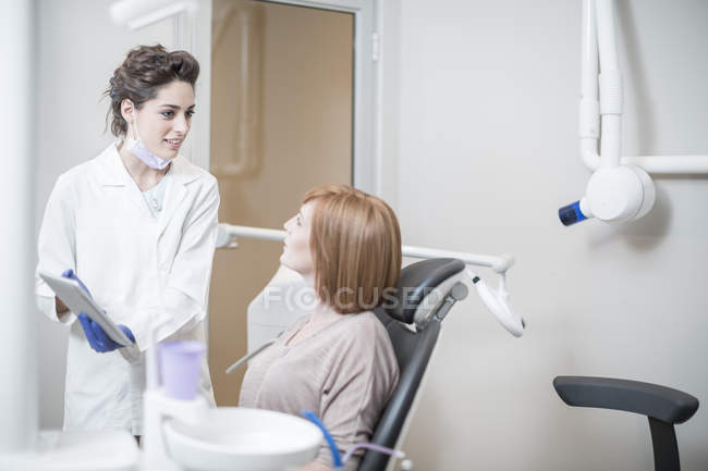 Стоматолог объясняет процедуру и результаты с пациентом — стоковое фото