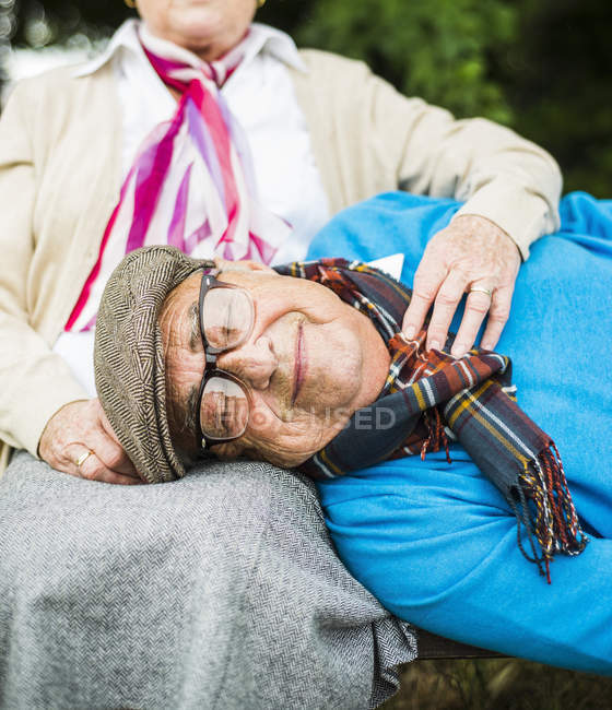 Ritratto di uomo anziano sdraiato con la testa sulle ginocchia della moglie — Foto stock