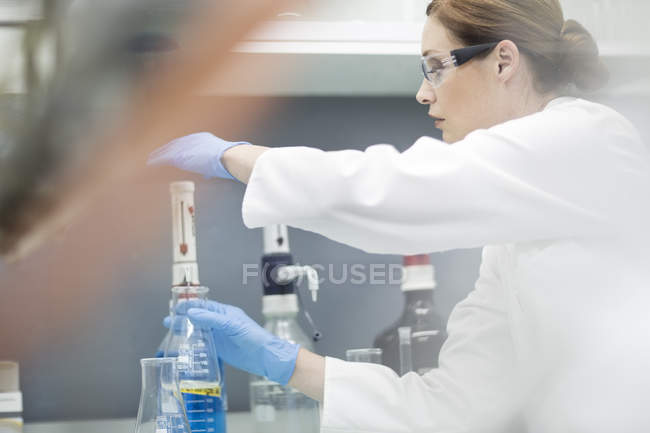 Femelle Scientifique travaillant avec du liquide en laboratoire — Photo de stock