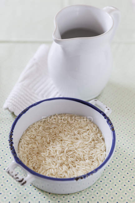 Басмати намочил рис в горшке и кувшине воды — стоковое фото