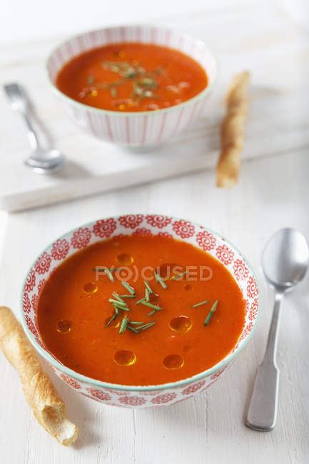 Cold bell pepper soup with bread sticks in bowl on white wood — healthy ...