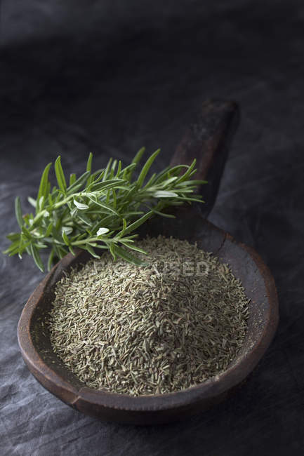Wooden spoon with rosemary on textile, closeup — Stock Photo