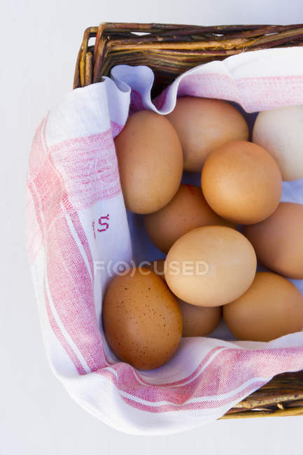 Primer plano de huevos marrones en cesta con servilleta - foto de stock