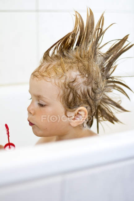 Girl With Funny Hairstyle Bursting Bubbles In Tub Head And