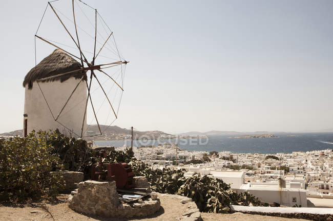 Grécia, Mykonos, Vista do moinho de vento tradicional contra a água — Fotografia de Stock