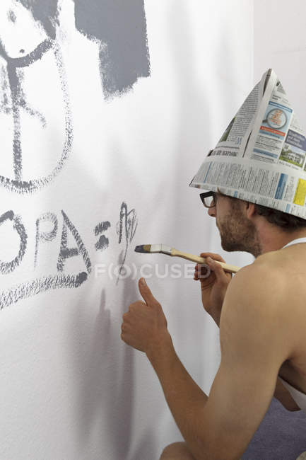 Giovane uomo pittura muro a casa — Foto stock