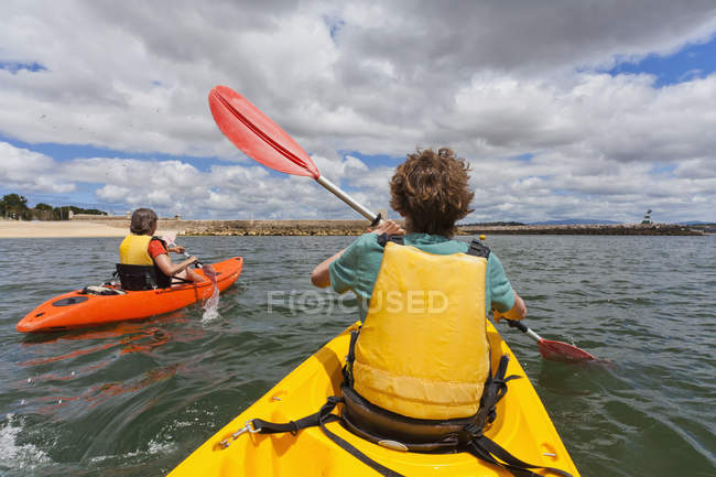 Portugal, Lagos, Teenage boy and mature woman rowing Kayak — Stock Photo