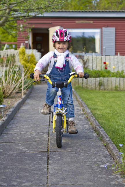 Ragazza in bicicletta in cortile — Foto stock