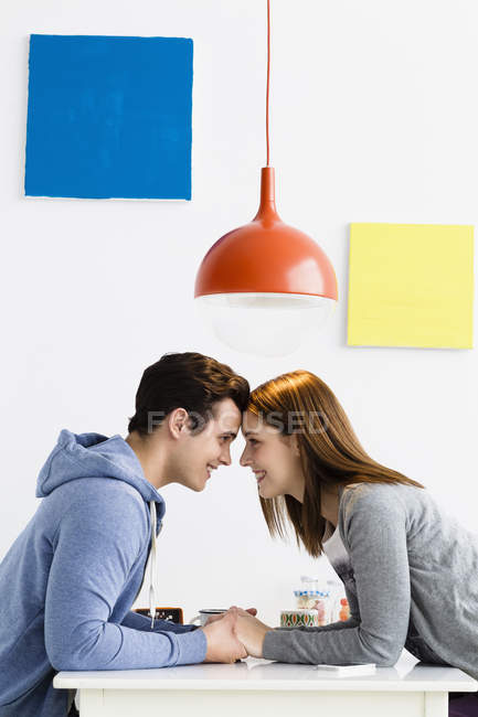 Pareja joven mirándose, sonriendo - foto de stock